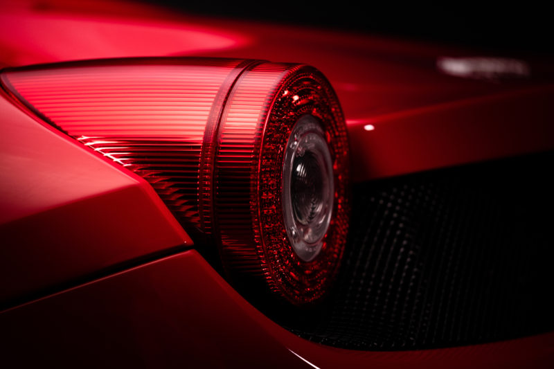 A close up shot of a rear tail light of a red Ferrari
